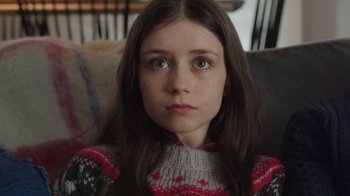 Movie still from “Snow Day” (2022), directed by Michael Lembeck – A young girl with long hair wearing a sweater; Close Up shot, Low angle