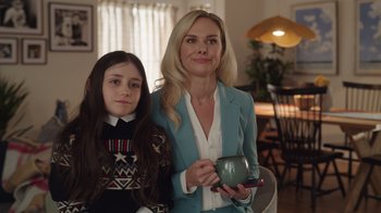 Movie still from “Snow Day” (2022), directed by Michael Lembeck – A woman and a young girl posing for a picture; Medium shot, Over the shoulder angle