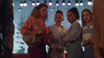 Movie still from “Snow Day” (2022), directed by Michael Lembeck – A group of young women standing next to each other in front of lights; Medium shot, Over the shoulder angle