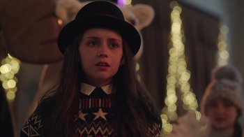Movie still from “Snow Day” (2022), directed by Michael Lembeck – A young woman wearing a hat and a sweater; Close Up shot, Over the shoulder angle