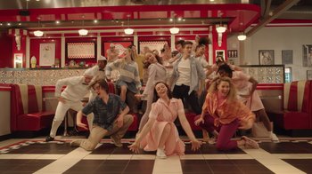 Movie still from “Snow Day” (2022), directed by Michael Lembeck – A group of people posing for a picture in a diner; Wide shot, High angle