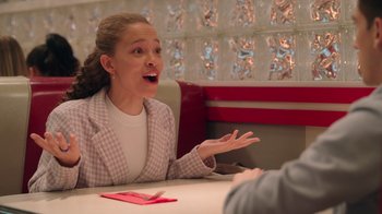 Movie still from “Snow Day” (2022), directed by Michael Lembeck – A woman sitting at a table in front of a man; Medium shot, Over the shoulder angle