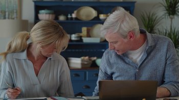 Movie still from “Snow Day” (2022), directed by Michael Lembeck – A man and a woman are looking at a laptop computer; Medium shot, Over the shoulder angle