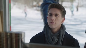 Movie still from “Snow Day” (2022), directed by Michael Lembeck – A young man wearing a gray scarf and a black jacket; Close Up shot, Over the shoulder angle