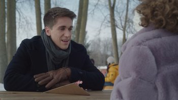 Movie still from “Snow Day” (2022), directed by Michael Lembeck – A young man sitting at a table with a teddy bear; Close Up shot, Over the shoulder angle