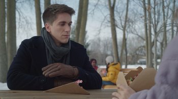 Movie still from “Snow Day” (2022), directed by Michael Lembeck – A man sitting at a table with a box of food; Close Up shot, Over the shoulder angle