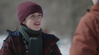 Movie still from “Snow Day” (2022), directed by Michael Lembeck – A young woman wearing a purple hat and scarf; Close Up shot, Over the shoulder angle