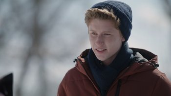 Movie still from “Snow Day” (2022), directed by Michael Lembeck – A young man wearing a winter hat and a jacket; Close Up shot, Over the shoulder angle