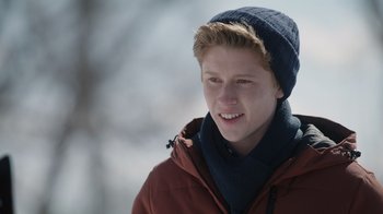 Movie still from “Snow Day” (2022), directed by Michael Lembeck – A young man wearing a winter hat and a jacket; Close Up shot, Over the shoulder angle