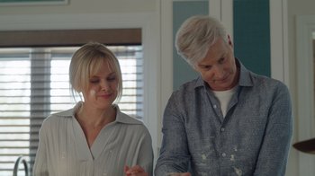 Movie still from “Snow Day” (2022), directed by Michael Lembeck – A man and a woman standing next to each other in a room; Medium shot, Over the shoulder angle