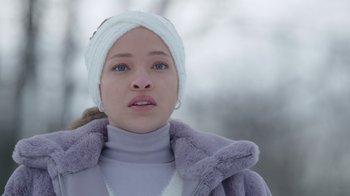 Movie still from “Snow Day” (2022), directed by Michael Lembeck – A young woman wearing a head band and a purple jacket; Close Up shot, Low angle