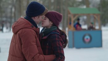 Movie still from “Snow Day” (2022), directed by Michael Lembeck – A man and a woman kissing in the snow; Medium shot, Over the shoulder angle