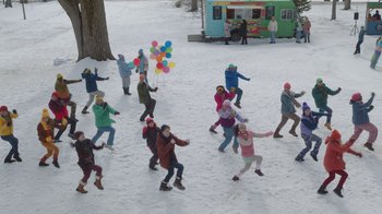 Movie still from “Snow Day” (2022), directed by Michael Lembeck – A group of people in the middle of a snow covered field; Extreme Wide shot, High angle