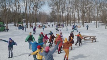 Movie still from “Snow Day” (2022), directed by Michael Lembeck – A group of people in the middle of a snow covered field; Extreme Wide shot, High angle