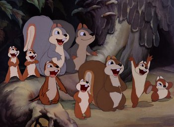 Movie still from “Snow White and the Seven Dwarfs” (1937), directed by Larry Morey – A group of cartoon characters sitting and standing in front of a cave; Wide shot, High angle