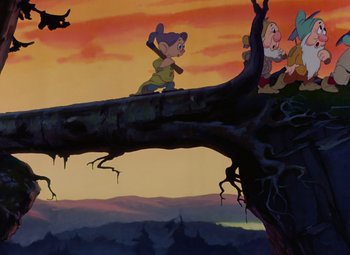Movie still from “Snow White and the Seven Dwarfs” (1937), directed by Larry Morey – A group of people sitting on top of a tree branch; Wide shot, Low angle