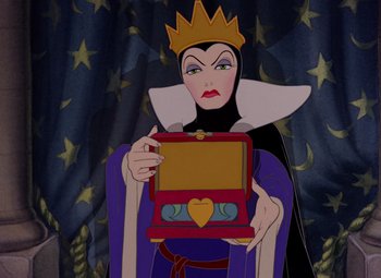 Movie still from “Snow White and the Seven Dwarfs” (1937), directed by Larry Morey – A woman holding an open box in front of her face; Close Up shot, Over the shoulder angle