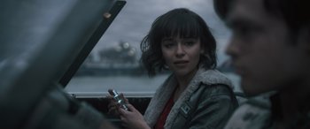 Movie still from “Solo: A Star Wars Story” (2018), directed by Ron Howard – A woman sitting in a car holding a cell phone; Close Up shot, Over the shoulder angle