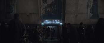 Movie still from “Solo: A Star Wars Story” (2018), directed by Ron Howard – A group of people standing in front of an elevator; Wide shot, Over the shoulder angle