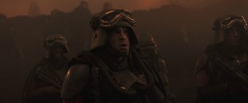 Movie still from “Solo: A Star Wars Story” (2018), directed by Ron Howard – A man wearing a helmet and a gas mask is standing in the dark; Close Up shot, Low angle