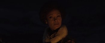 Movie still from “Solo: A Star Wars Story” (2018), directed by Ron Howard – A woman in a black jacket and a white fur collar; Close Up shot, Low angle