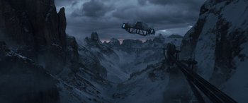 Movie still from “Solo: A Star Wars Story” (2018), directed by Ron Howard – An image of an airplane flying in the sky over a mountain range; Extreme Wide shot, Low angle