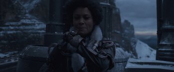 Movie still from “Solo: A Star Wars Story” (2018), directed by Ron Howard – A woman in a black leather jacket and a white fur collar; Close Up shot, Over the shoulder angle