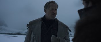 Movie still from “Solo: A Star Wars Story” (2018), directed by Ron Howard – A man in a gray jacket is standing in the snow; Close Up shot, Low angle