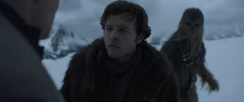Movie still from “Solo: A Star Wars Story” (2018), directed by Ron Howard – A man in a fur coat looking to his left; Close Up shot, Low angle