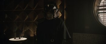 Movie still from “Solo: A Star Wars Story” (2018), directed by Ron Howard – A person wearing a black outfit and a helmet; Close Up shot, Over the shoulder angle