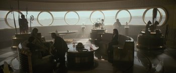 Movie still from “Solo: A Star Wars Story” (2018), directed by Ron Howard – People are sitting at a table in a room; Wide shot, High angle