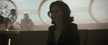 Movie still from “Solo: A Star Wars Story” (2018), directed by Ron Howard – A woman in a black jacket and a gold necklace; Close Up shot, Over the shoulder angle