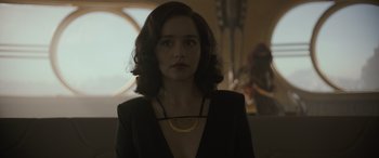Movie still from “Solo: A Star Wars Story” (2018), directed by Ron Howard – A woman in a black jacket and a gold necklace; Close Up shot, Over the shoulder angle