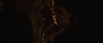 Movie still from “Solo: A Star Wars Story” (2018), directed by Ron Howard – A woman in a fur coat is standing in the dark; Close Up shot, Over the shoulder angle