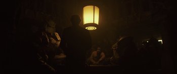 Movie still from “Solo: A Star Wars Story” (2018), directed by Ron Howard – A man standing under a lamp in a dark room; Medium shot, Low angle