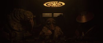Movie still from “Solo: A Star Wars Story” (2018), directed by Ron Howard – A person wearing a mask and a long coat; Medium shot, Over the shoulder angle