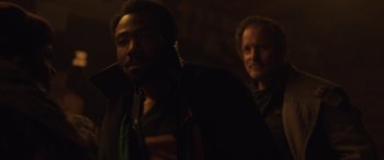 Movie still from “Solo: A Star Wars Story” (2018), directed by Ron Howard – A man and a woman standing next to each other in a dark room; Close Up shot, Over the shoulder angle