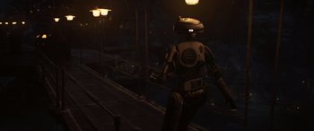 Movie still from “Solo: A Star Wars Story” (2018), directed by Ron Howard – An image of a robot walking on a bridge at night; Wide shot, Over the shoulder angle