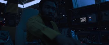 Movie still from “Solo: A Star Wars Story” (2018), directed by Ron Howard – Lando calrissian in a dark room in a star wars movie; Medium shot, Over the shoulder angle