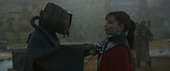 Movie still from “Solo: A Star Wars Story” (2018), directed by Ron Howard – A woman is holding a robot in her hand; Close Up shot, Over the shoulder angle