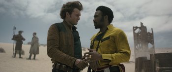 Movie still from “Solo: A Star Wars Story” (2018), directed by Ron Howard – Two men are standing next to one another; Medium shot, Over the shoulder angle