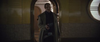 Movie still from “Solo: A Star Wars Story” (2018), directed by Ron Howard – A man holding a gun while standing in front of a door; Medium shot, Low angle