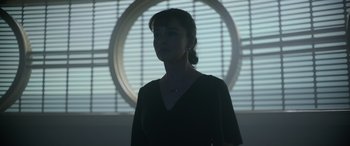 Movie still from “Solo: A Star Wars Story” (2018), directed by Ron Howard – A woman standing in front of a circular window; Medium shot, Low angle