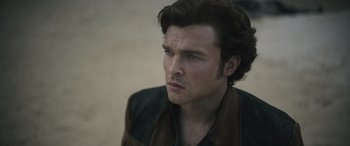 Movie still from “Solo: A Star Wars Story” (2018), directed by Ron Howard – A person wearing a jacket; Close Up shot, Over the shoulder angle