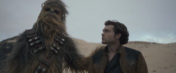 Movie still from “Solo: A Star Wars Story” (2018), directed by Ron Howard – A man and a wookiee in the desert; Medium shot, Low angle