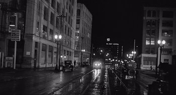Movie still from “Some Like It Hot” (1959), directed by Billy Wilder – A black - and - white photo of a city street at night; Extreme Wide shot, Low angle