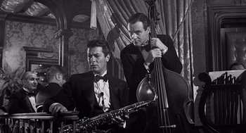 Movie still from “Some Like It Hot” (1959), directed by Billy Wilder – Two men in suits and bow ties are playing musical instruments; Medium shot, Low angle