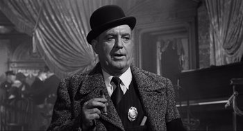 Movie still from “Some Like It Hot” (1959), directed by Billy Wilder – An older man wearing a suit and a hat; Medium shot, Low angle