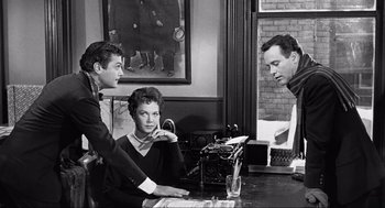 Movie still from “Some Like It Hot” (1959), directed by Billy Wilder – Three people are sitting at a table with a typewriter; Medium shot, Over the shoulder angle