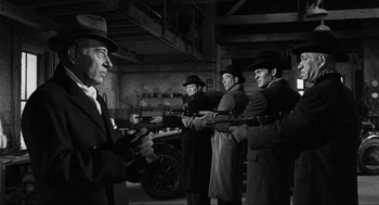 Movie still from “Some Like It Hot” (1959), directed by Billy Wilder – A group of men in suits and hats holding guns; Medium shot, Low angle